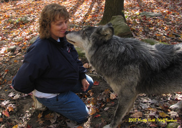 Dr. Susie Myers kissing Nira, a wolf at Wolf Timbers during a photo shoot.